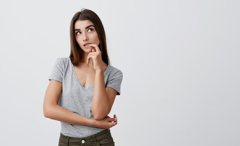 Mujer con camiseta gris pensativa