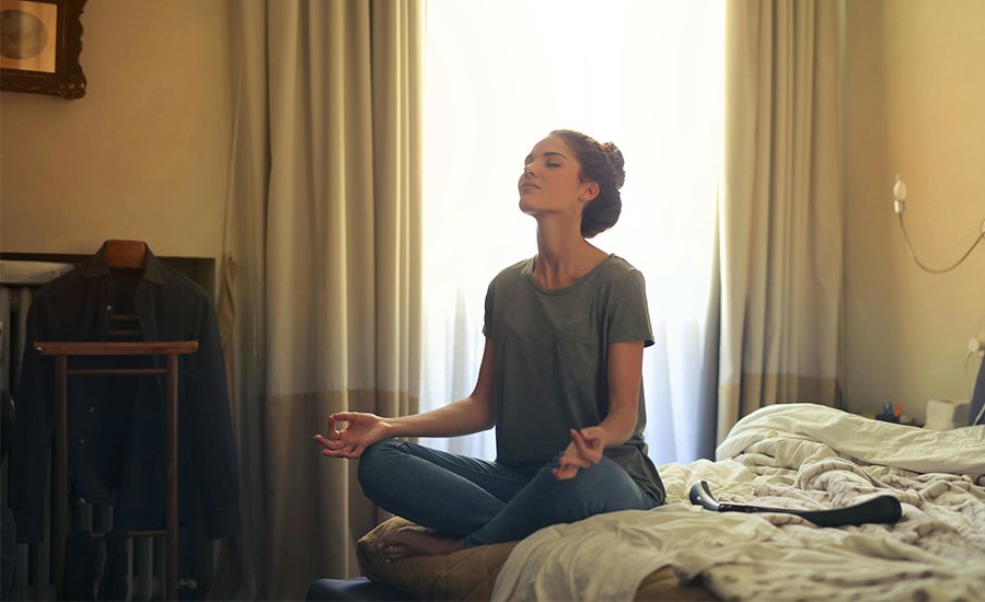 Mujer meditando en la cama