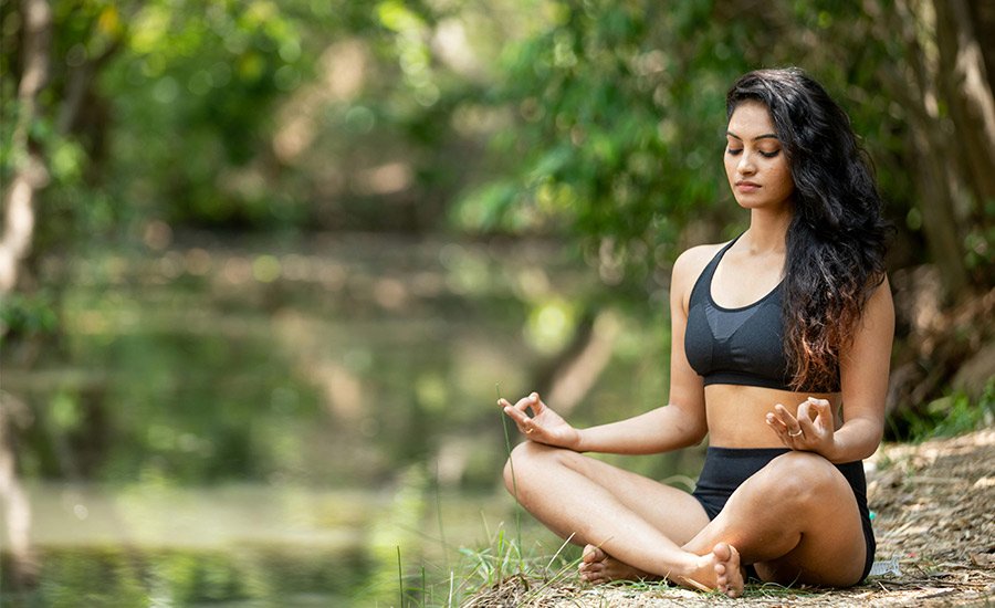 mujer meditando en la naturaleza para sentirse mejor con ella misma