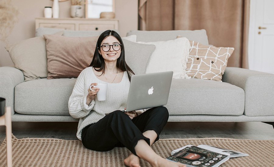 Mujer sentada en el suelo con un ordenador